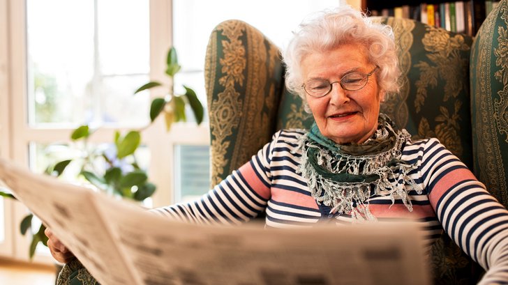 Seniorin liest Zeitung