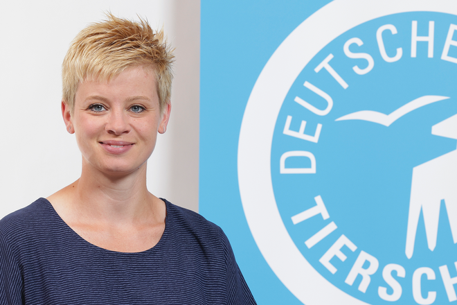 Portrait von Eva Rönspiess vor dem Logo des Deutschen Tierschutzbundes