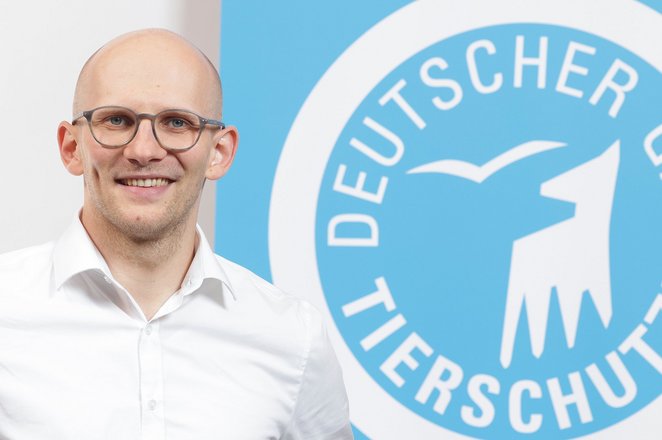 Portrait von Simon Berghane vor dem Logo des Deutschen Tierschutzbundes